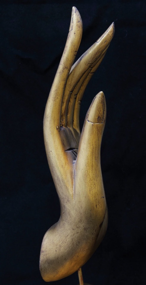 Houten Buddha hand tegen donkere achtergrond